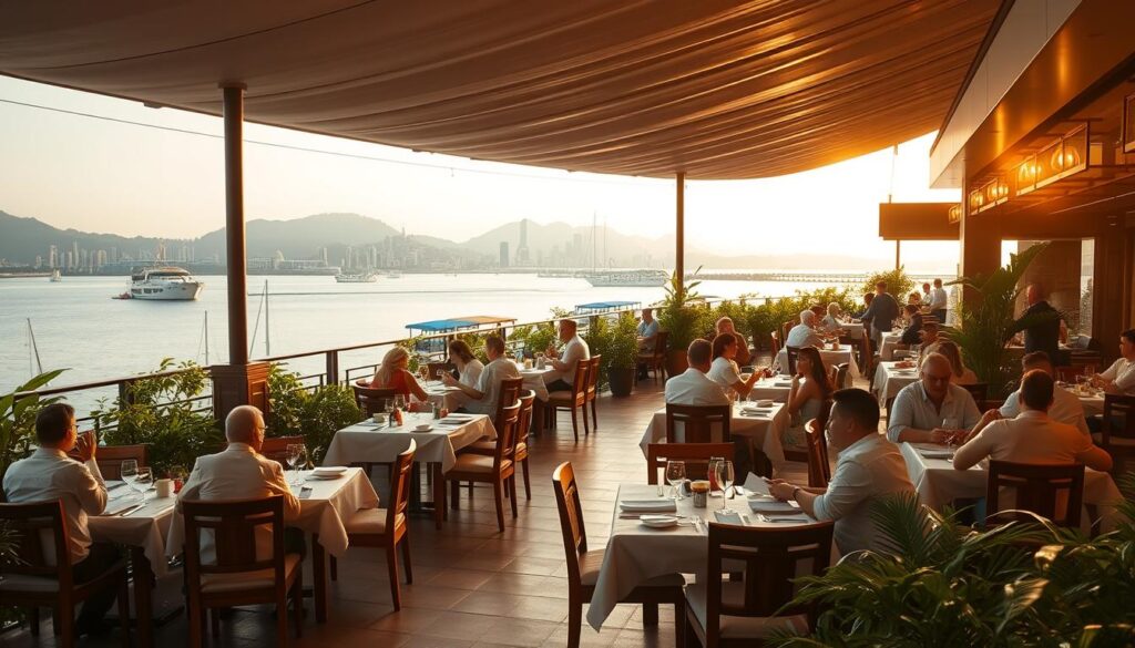 A sprawling, open-air waterfront dining establishment, with a panoramic view of the harbor and glistening cityscape in the distance. The scene is bathed in warm, golden lighting, creating a smart-casual, tranquil ambiance. Elegant wooden tables and chairs are arranged in an inviting layout, with crisp white linens and gleaming tableware. Lush foliage and potted plants frame the dining area, adding a touch of nature to the urban setting. Diners are engaged in lively conversation, savoring delectable Chinese cuisine against the backdrop of a serene, picture-perfect waterfront. The overall atmosphere evokes a sense of refined sophistication and relaxation.